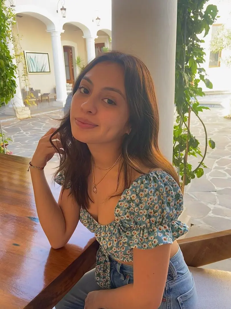 A woman sitting on top of a wooden table.
