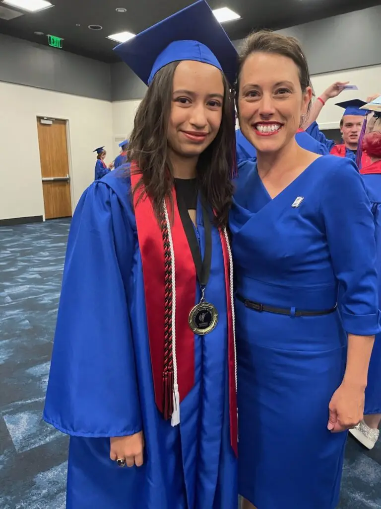 A woman and girl in graduation attire posing for the camera.