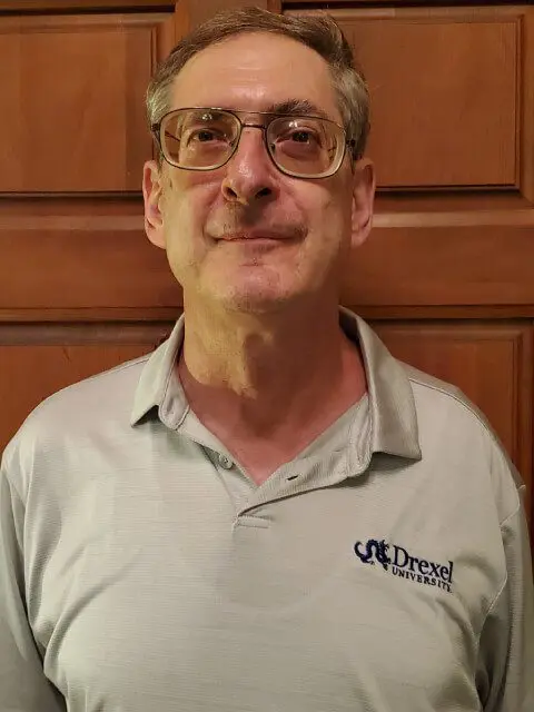 A man with glasses and a gray shirt